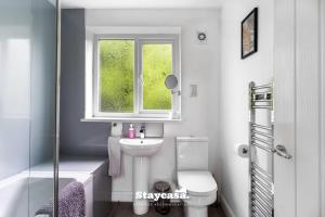 a bathroom with a sink and a toilet and a window at Spacious 2br Home W Garden 2-min Walk To Town in Stockport +21 photos