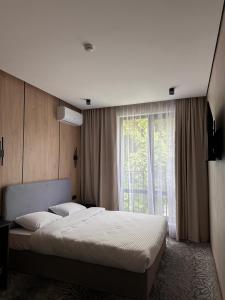 a bedroom with a large bed and a window at MILANIUM hotel in Almaty