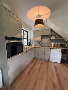 a kitchen with white cabinets and a white refrigerator at Highland Nook for 4 in Fort William +38 photos