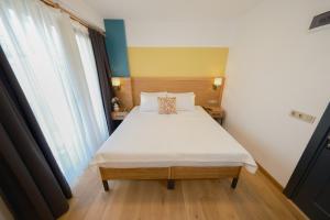 Un dormitorio con una cama grande con sábanas blancas. en Pastel İstanbul, en Estambul