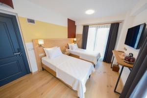 a hotel room with two beds and a television at Pastel İstanbul in Istanbul