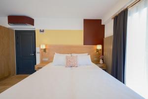 1 dormitorio con 1 cama blanca grande y puerta azul en Pastel İstanbul, en Estambul