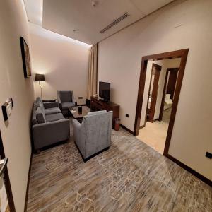 a living room with two chairs and a couch and a television at Qaser Al Hamra Hotel in Riyadh +21 photos