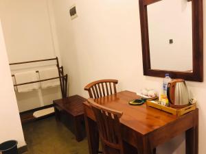 a dining room table with a mirror and a chair at Kadulla Resort in Habarana +45 photos