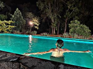 哈伯勒内Kadulla Resort的夜晚在游泳池里的一个男人