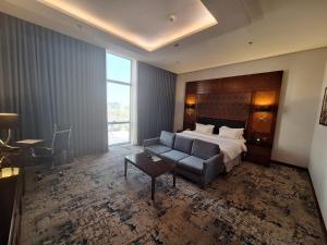 a hotel room with a bed and a couch at Qaser Al Hamra Hotel in Riyadh