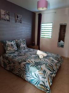 a bedroom with a bed with a comforter on it at T2 à deux pas des plages dans le bourg in Le Gosier