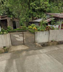 a fence on the side of a road next to a house at Belmoro Transient House in Bacacay