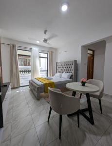 un salon avec un lit et une table et un tableablish dans l'établissement Nancy's Haven studio apartment, à Mombasa