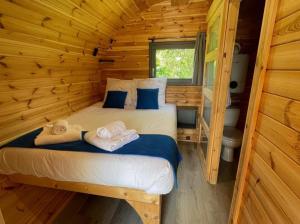 a bedroom with a bed in a log cabin at Camping Les Prés du Roi in Sommières +36 photos