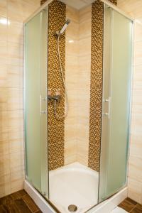 a shower with a glass door in a bathroom at Belkert Étterem és Panzió in Debrecen