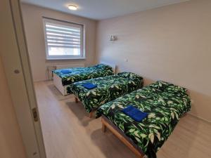 a room with three beds and a window at FB Apartaments in Plungė