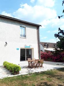 a building with two benches in front of it at La Sucrerie - chambres à la campagne in Fontenay