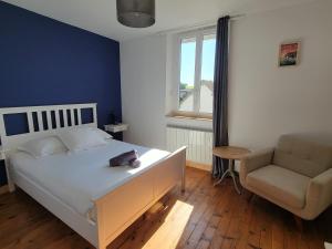 a bedroom with a white bed and a chair at La Sucrerie - chambres à la campagne in Fontenay
