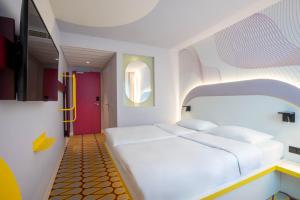 オスナブリュックにあるPrize by Radisson, Osnabruckの白いベッドとカラフルなドアのある寝室