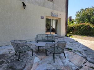 three chairs and a table in front of a building at La Sucrerie - chambres à la campagne in Fontenay
