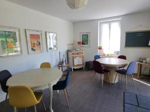 a dining room with two tables and chairs and a table at La Sucrerie - chambres à la campagne in Fontenay
