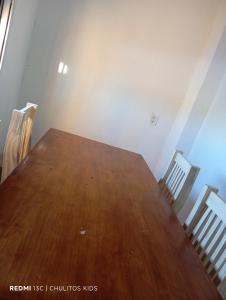 a wooden table in a room with two chairs at El descanso in San Pedro
