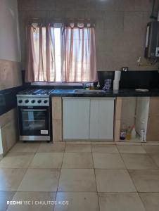 a kitchen with a stove and a sink and a window at El descanso in San Pedro