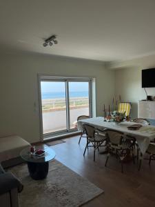 a living room with a table and chairs with a view at Apartamento de Férias in São Félix da Marinha