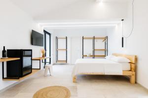 ein weißes Schlafzimmer mit Bett und Fernseher in der Unterkunft Silenza B&B, Charme, Comfort e Relax nel Gargano in Mattinata