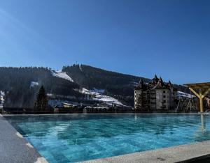 a large swimming pool in front of a mountain at Mountain Krystal in Bukovel