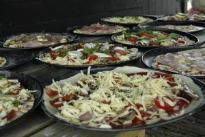un montón de pizzas en sartenes en una mesa en Landhoeve, en Zwarteweg 10 fotos más
