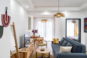 a living room with a blue couch and a tv at Marina Bay One & Two Bedroom Apartment, Swimming pool, gym, workspace ,Wonderiss Homes Westland Living in Nairobi