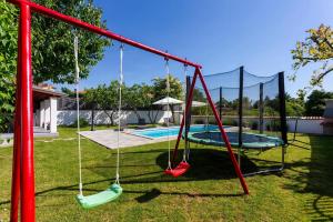 une balançoire dans une cour avec une piscine dans l'établissement Stone House Furlani, à Svetvinčenat