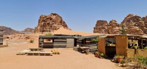 a building in the desert with mountains in the background at Martian Desert Camp in Wadi Rum
