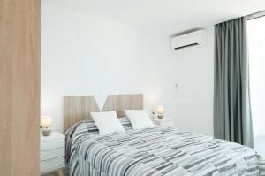 a white bedroom with a bed and a window at Isla Bonita Blik by Huskalia in Puerto Naos +18 photos