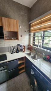 Una pequeña cocina con fregadero y estufa. en Home of comfort and luxury, en Apenkwa