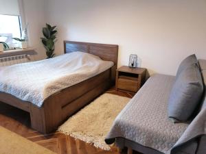 a bedroom with a bed and a nightstand and a bed sidx sidx sidx sidx at Magnolia in Sobolew