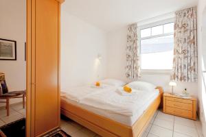 ツィノヴィッツにあるFerienwohnung Haus Roland Whg 26のベッドと窓のある小さな寝室