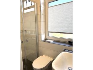 ツィノヴィッツにあるFerienwohnung Haus Roland Whg 26のトイレ、洗面台、窓のあるバスルーム +8枚の写真