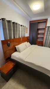 Un dormitorio con una gran cama blanca y una ventana. en Home of comfort and luxury, en Apenkwa