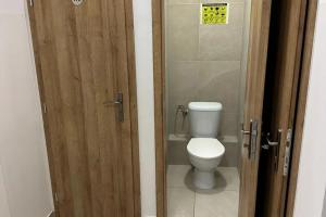 Un baño con inodoro y puerta de madera. en Meštiansky dom, en Stupava