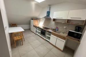 Una cocina con gabinetes blancos y una mesa en ella. en Meštiansky dom, en Stupava