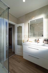 un bagno con lavandino e doccia in vetro di Nuevo Luanco By Silastur a Gijón