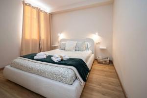 una camera da letto con un letto con due asciugamani sopra di Nuevo Luanco By Silastur a Gijón