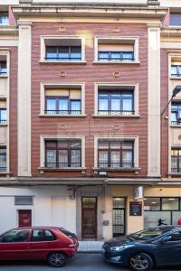 due auto parcheggiate di fronte a un edificio di mattoni di Nuevo Luanco By Silastur a Gijón