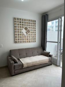 a couch sitting in a living room with a window at LK Centro 1 in Belo Horizonte
