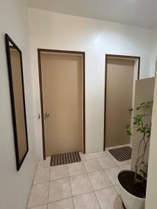 un couloir avec deux portes et une plante en pot dans l'établissement Casa de Lucas, à Moalboal