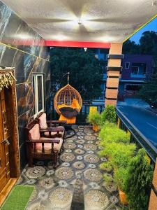 a patio with chairs and a swing on a balcony at Coorgsierra in Madikeri +16 photos