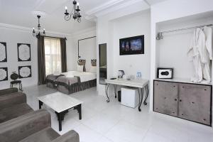 Habitación blanca grande con cama y sofá en The one family boutique, en Tiflis