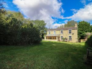 a large brick house with a large yard at Larkspur Cottage in Alford