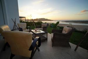 a patio with chairs and a table with a view of the ocean at Rabat Oceanfornt Luxury Villa Plage Val d Or in Temara