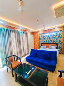 a living room with a blue couch and a table at Hotel Royal King in Lucknow