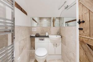 a bathroom with a toilet and a sink at Luxury Farmhouse Retreat with Private Hot Tub & EV in Kentisbury