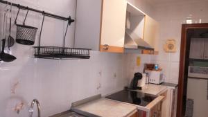 a kitchen with a sink and a microwave at Casa rural Regajo Lobos in San Bartolomé de Béjar